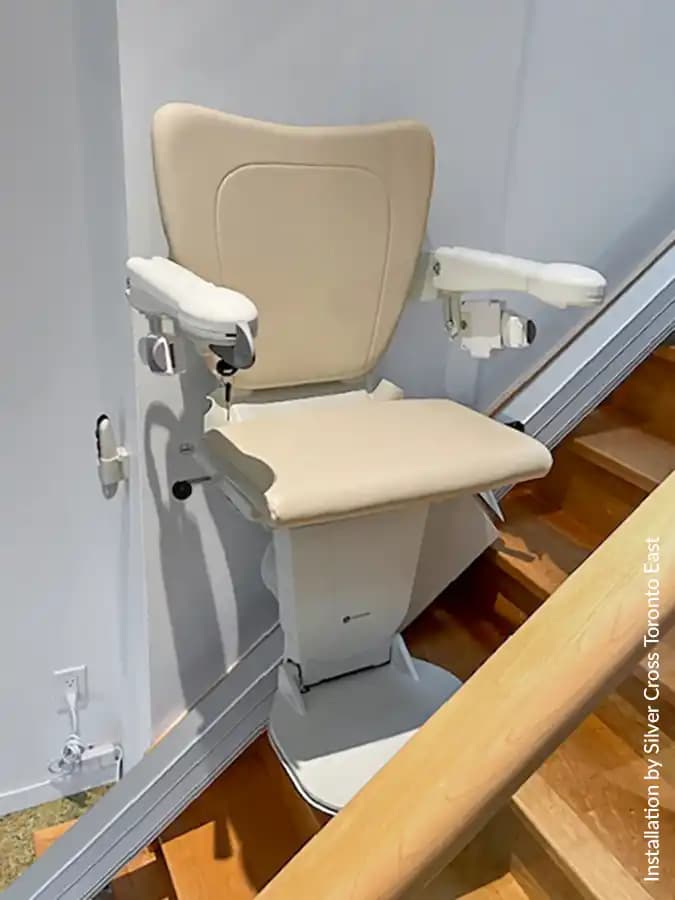 Savaria Handicare 1100 straight stairlift with Style Seat in vanilla beige, padded armrests, folding footrest, multi-drive covered rail, and retractable seatbelt