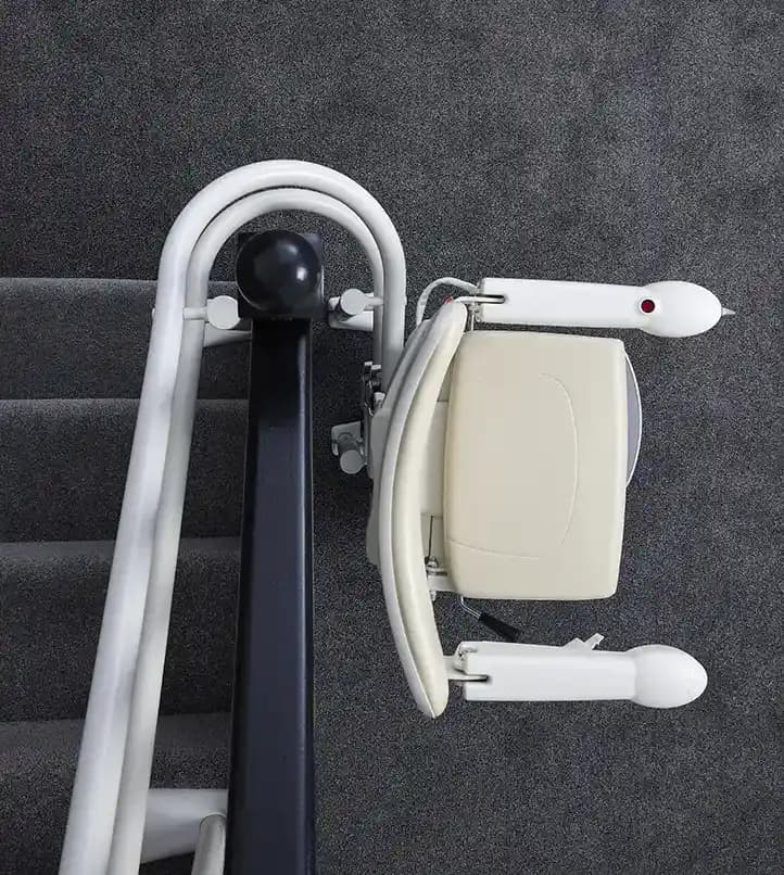 Savaria Handicare 4000 twin-rail curved stairlift with Simplicity Seat, 180-degree parking feature, folded seat and armrests on carpeted stairs viewed from above