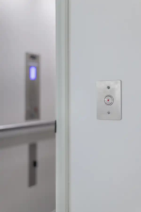 Savaria home elevator hall call button with illuminated position indicator and single call station mounted on white wall
