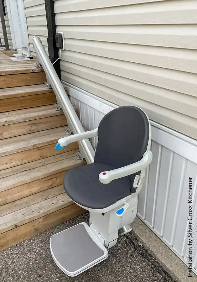 Savaria Handicare 1000 outdoor straight stairlift with Smart Seat in slate upholstery, water-resistant cover, aluminum rail, and weatherproof footrest on exterior wood deck stairs