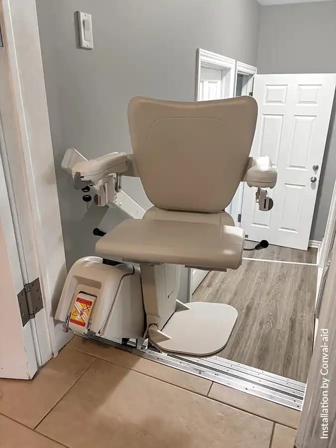 Savaria Handicare 1100 straight stairlift with Style Seat in vanilla beige, power swivel at top landing, slim multi-drive rail, and Zero Intrusion system near doorway